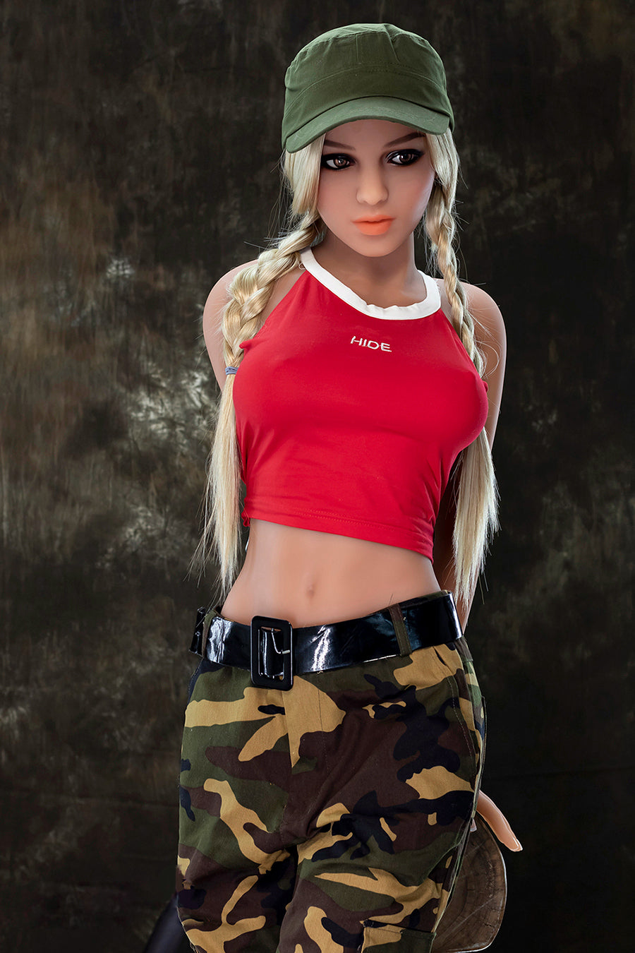 The full-sized sex doll is standing with its hands behind its back.